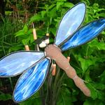 Blue, white and clear wispy glass accent the wings on this dragonfly.  Metal allowed to rust on the body with a rock for the head.  Over sizes fused glass eyes attach to the head.  The dragonfly is placed on top of a 5 copper catkin, cattail metal sculpture.