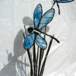 Double Dragonfly with blue wispy wings on metal cattail with catkins. As this ages the cattail will rust.